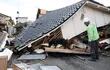 El perro de rescate internacional Elsa y su guía Yasuhiro Morita (R) buscan a los desaparecidos en una casa derrumbada por un fuerte terremoto en Wajima, Prefectura de Ishikawa, Japón central, el 5 de enero de 2024