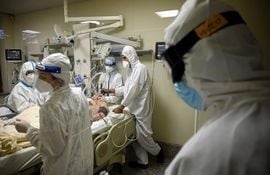 Un paciente con Covid internado en una unidad de terapia intensiva recibe asistencia médica.