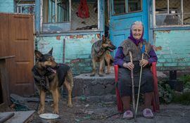 -FOTODELDIA- AME7384. KIEV (UCRANIA), 06/05/2022.- Una mujer posa junto a sus dos perros frente a su casa, hoy, en Kiev (Ucrania). EFE/ Miguel Gutiérrez
