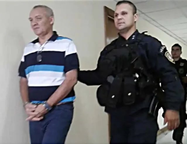 Anastasio Mieres Burgos, es llevado por un agente de policía, en tribunales. Fue condenado a 25 años de prisión más otros 10 años como medida de seguridad.
