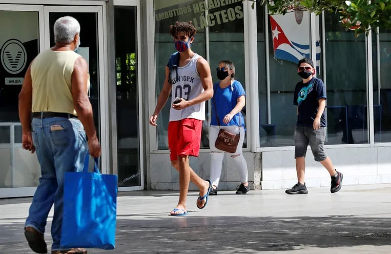 Varias personas usan tapabocas mientras caminan por una calle, en La Habana, Cuba, que aumentó hoy la censura en redes.  (EFE)
