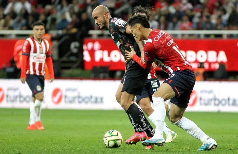 Carlos González domina el balón ante la marca de Jesús Orozco, de las Chivas, durante el partido que Toluca ganó 2-1 con una anotación del delantero paraguayo.
