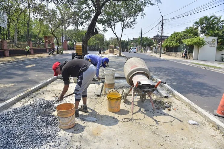 Dos hombres trabajando en un punto de la avenida Carlos Antonio López, en Asunción. Los trabajos, que están atrasados, muestran lentos avances en el paseo central.