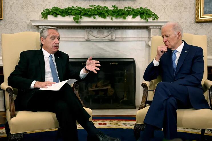 El presidente Argentina, Joe Biden  (d) dialoga con el mandatario argentino, Alberto Fernández, en el salón Oval de la Casa Blanca.  (AFP)