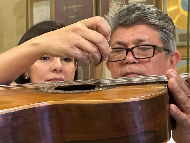 Luz y Aníbal Borja observan los detalles de la guitarra José Ramírez (1911) que perteneció al compositor paraguayo Agustín Pío Barrios (Mangoré).