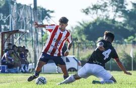 El delantero albirrojo, Diego Giménez escapa de la marca del defensor Alejandro Ayala de Presidente Hayes. (Foto: APF)