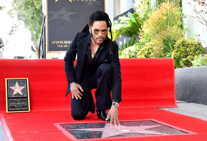 El músico Lenny Kravitz posa con su estrella en el Paseo de la Fama de Hollywood.