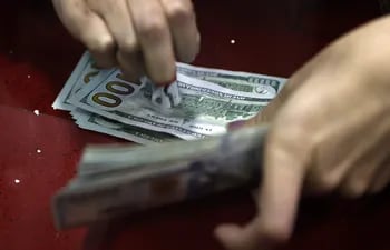 Una mujer mientras cuenta billetes de dólar en una casa de cambio de divisas. (EFE)