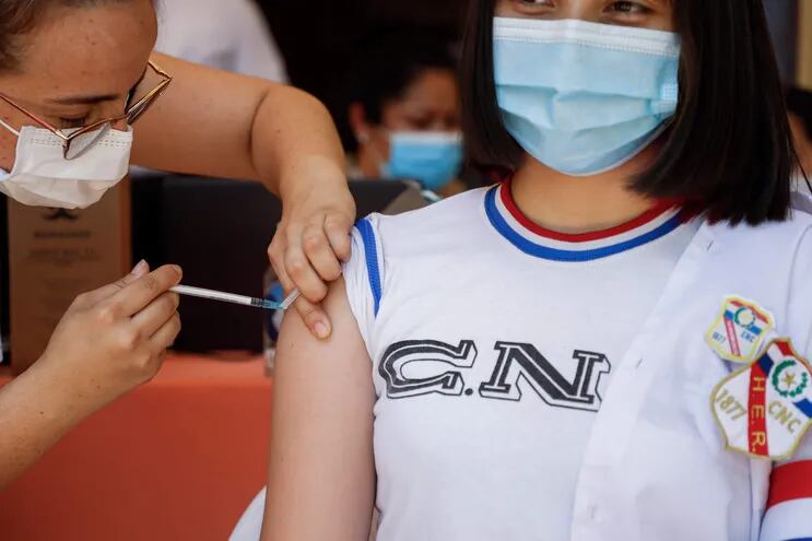 Una alumna recibe una dosis de vacuna contra la covid-19 en el Colegio Nacional de la Capital.