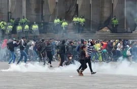 Miembros de las fuerzas del orden dispersan con gases a manifestantes durante un cacerolazo este viernes, en la Plaza Bolívar de Bogotá (Colombia).