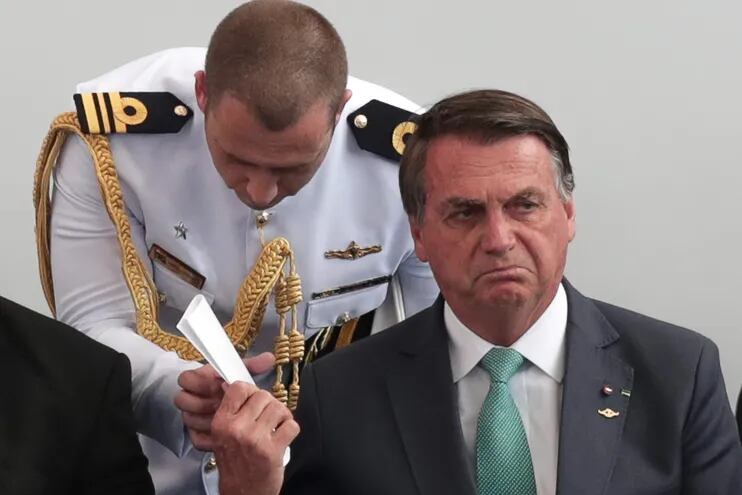 El presidente de Brasil, Jair Bolsonaro, entrega un papel a un miembro del protocolo durante la ceremonia de la Medalla al Mérito Deportivo Militar, en Río de Janeiro (Brasil).