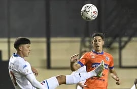 EL delantero de Nacional, Tiago Caballero, despeja el balón ante la presión de Ronald Cornet, volante ofensivo del 2 de Mayo PJC.