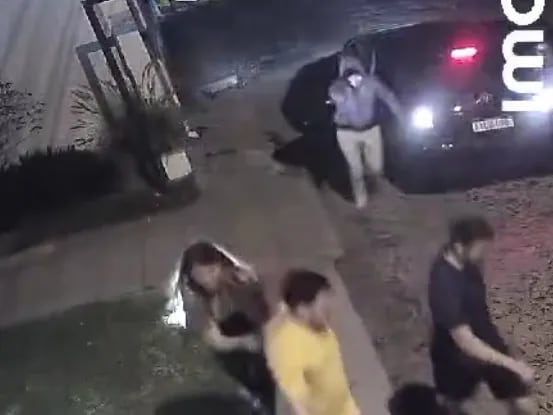 Momento en que uno de los asaltantes desciende del auto para apuntar con su arma de fuego a un grupo de personas en zona de Villa Morra de Asunción.