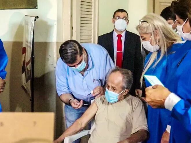 El ministro de Salud, doctor Julio Borba, aplicando la vacuna anticovid en el Hogar Santo Domingo. En total, se procederá a la inoculación en 78 hogares y casas de reposo en todo el país.