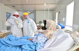Yakarta. El especialista en pulmones Wahyuningsih (i) y la doctora Devita Rere (d) visitan a un paciente en el hospital Pertamina Simprug designado para tratar a pacientes con coronavirus COVID-19.