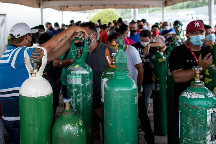 Familiares de pacientes infectados con Covid-19 enfrentan horas de espera desde temprano en la mañana para abastecer sus cilindros de oxígeno en la empresa Carboxi, que comercializa gases en Manaos, Amazonas, Brasil.