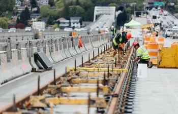 Obreros mientras trabajan en la renovación del puente flotante Homer M. Hadley Memorial sobre el lago Washington, el 16 de abril de 2019, en Seattle (EE.UU.).