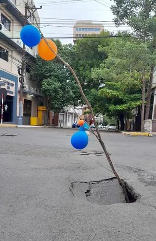 Sobre Yegros, esquina Fulgencio R. Moreno, en pleno centro de Asunción, el asfalto se está hundiendo. Para alertar a los conductores sobre el peligroso bache, los vecinos lo "adornaron" con globos.