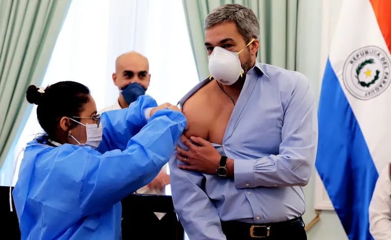 El presidente Mario Abdo Benítez recibe la dosis de la vacuna contra la influenza. Observa más atrás, el ministro Julio Mazzoleni. Fue ayer en Palacio de López.