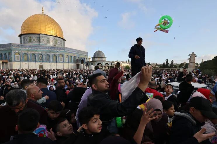 Musulmanes intercambian regales en las inmediaciones de la mezquita de Al Aqsa, en Jerusalén, este viernes.