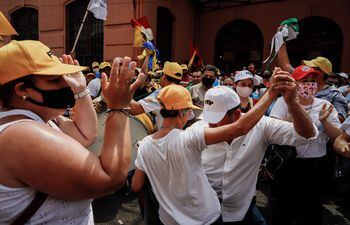 Docentes bailan durante una protesta para exigir al Gobierno un aumento salarial, durante los días de movilización frente a la sede del Ministerio de Hacienda en Asunción.
