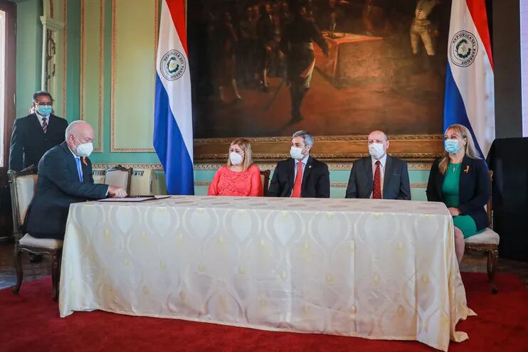 El representante de la ONU, Mario Samaja (izq.) firma el Acta de Compromiso en Palacio de López. Observan Sandra Quiñónez (i),  Abdo, Diesel y Celina Lezcano.