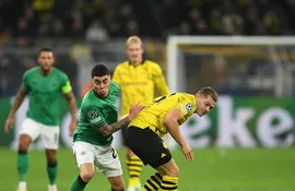 Miguel Almirón, jugador del Newcastle, pelea el balón con Rami Bensebaini, del Borussia Dortmund.
