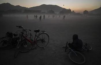 Un chico afgano rodeado de bicicletas observa un partido de fútbol en el parque Chaman-e-Hozori en Kabul.