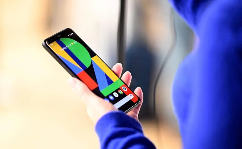(FILES) In this file photo taken on October 15, 2019, a woman holds the Google Pixel 4 phone during a Google product launch event in New York City. - Google's parent company Alphabet announced about 12,000 job cuts globally on January 20, 2023, citing a changing "economic reality", becoming the latest US tech giant to enact large-scale restructuring. The layoffs come a day after Microsoft said it would reduce staff numbers by 10,000 in the coming months, following similar cuts by Facebook owner Meta, Amazon and Twitter as the previously unassailable tech sector battles a major economic downturn. (Photo by Johannes EISELE / AFP)