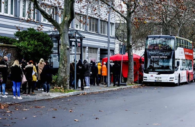 Un grupo de personas forma fila frente a un bus vacunatorio en Berlín, Alemania.