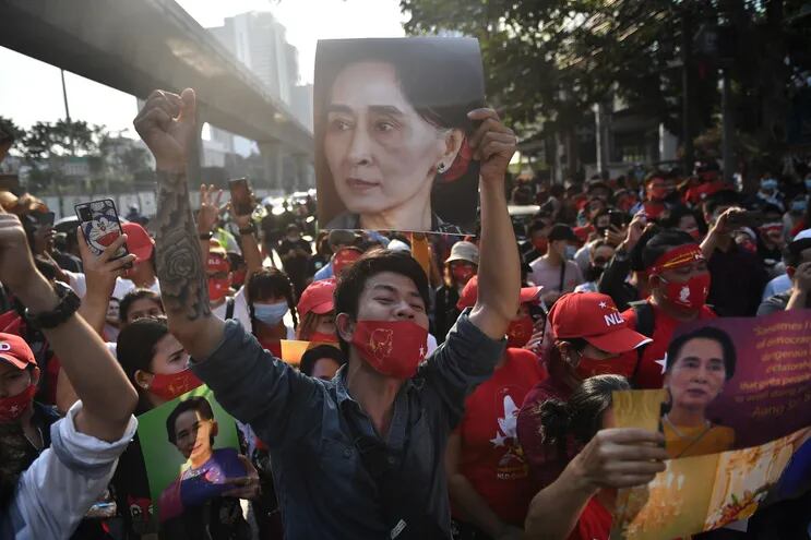 Migrantes de Myanmar (Birmania) sostienen retratos de Aung San Suu Kyi mientras participan en una manifestación frente a la embajada de Myanmar en Bangkok el 1 de febrero de 2021, después de que el ejército de Myanmar detuviera a la líder de facto del país, Aung San Suu Kyi, y al presidente del país en un golpe de estado.