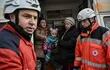 Miembros de la Cruz Roja Internacional ayudan en la evacuación de niños y mujeres en el oeste de Kiev, capital de Ucraniana. (AFP)