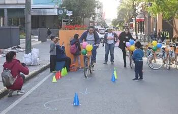 Niños y adultos disfrutan de un paseo en bici hoy, en calle Palma.