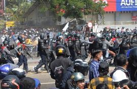 La policía de Birmania, armada con rifles automáticos, ataca a los manifestantes mientras continúan manifestándose contra el golpe militar del 1 de febrero en la capital, Naypyidaw, el 9 de febrero de 2021.