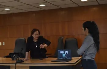 La jueza Lici Sánchez observa su reloj, momento en que recibe el aviso de que Armando Rotela no llegó al Palacio de Justicia para su audiencia preliminar.