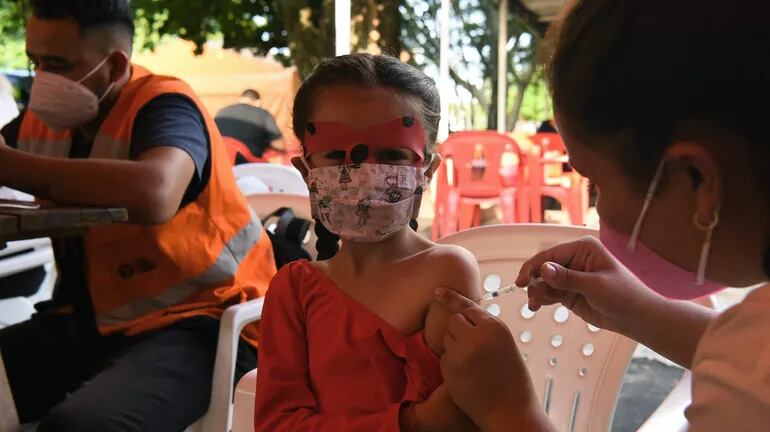 Los casos de COVID descendieron en la última semana en comparación a las anteriores. En la foto, una niña recibe una de las dosis de la vacuna contra la enfermedad en un puesto de San Lorenzo.