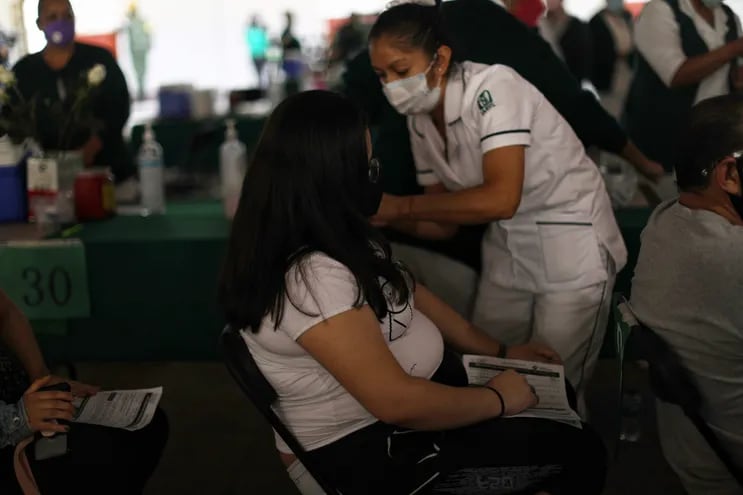Una embarazada recibe la dosis de la vacuna de Pfizer contra el COVID-19 en una escuela en Ciudad de México.