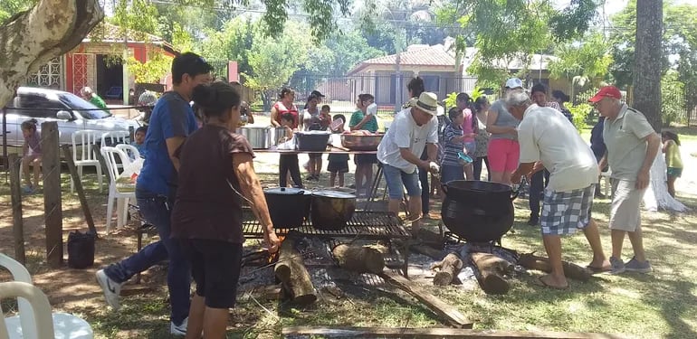 Los voluntarios del barrio y la capilla Santa Bárbara trabajan en la elaboración del almuerzo realizado ayer