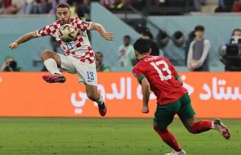 El jugador croata Nikola Vlasic (i) intenta dominar el balón ante la presencia del jugador marroquí Ilias Chair, durante el partido disputado ayer para definir el tercer puesto del Mundial de Qatar 2022.