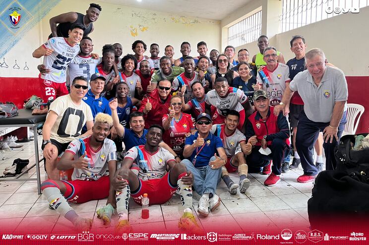 Éver Almeida (d) posa con los jugadores del El Nacional en vestuario celebrando la victoria.