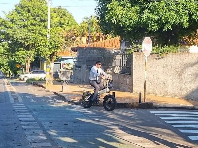 Con corbata y en bicicleta eléctrica este oficinista recorre la bicisenda sobre la calle San Alfonso, en el barrio Mburicaó de Asunción.
