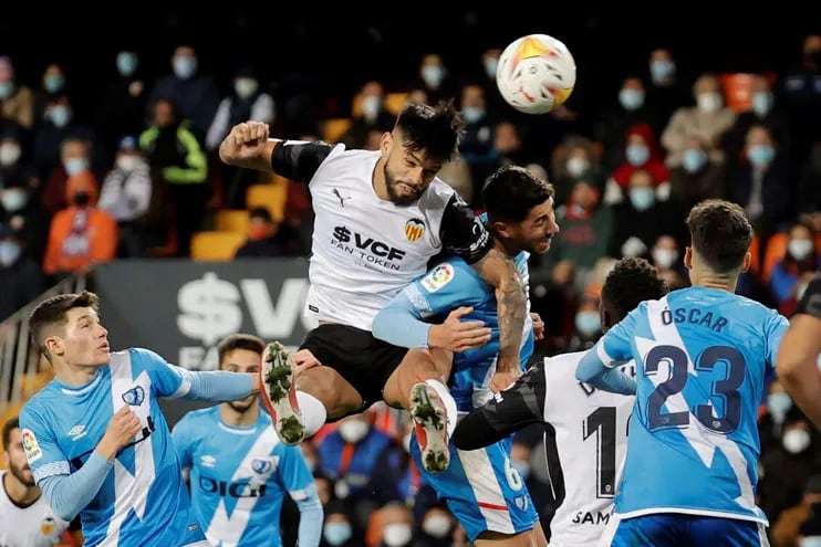 El defensa del Valencia, Omar Alderete (2i), remata el balón ante el centrocampista del Rayo Vallecano, Santi Comesaña, durante el encuentro correspondiente a la jornada decimoquinta de primera división, disputado hoy sábado en el estadio de Mestalla, en Valencia.
