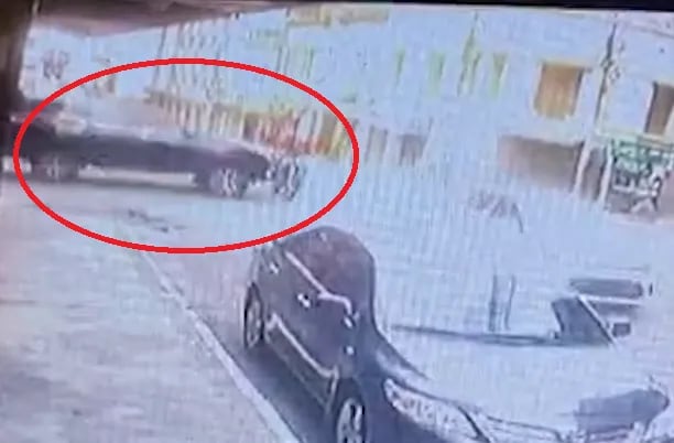 Captura de video del momento exacto en que una camioneta embiste violentamente contra un motociclista.