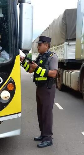 Momento en que un agente de la Patrulla Caminera procede a hacer el control al chofer de un bus internacional en el departamento de Paraguarí.