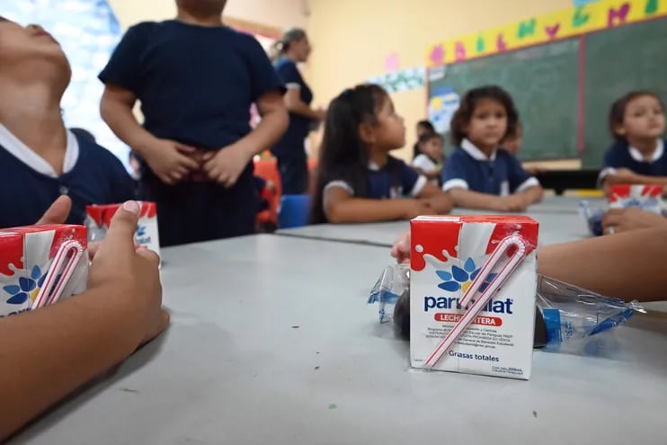 Niños consumen la merienda escolar en una institución educativa de Asunción.