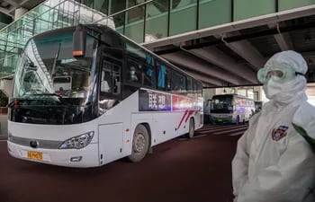 Un bus que transporta a enviados de la OMS sale del aeropuerto de Wuhan, China.