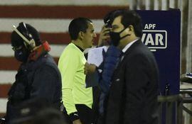 El árbitro Juan López revisa el VAR durante el partido entre Cerro y River. En la primera etapa se frenó cinco veces el encuentro.