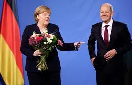 El canciller alemán, Olaf Scholz (d) , junto a su antecesora en el cargo, Ángela Merkel (i), durante su ceremonia de investidura en el cargo, hoy, en Berlín. El Partido Socialdemócrata (SPD) recuperó el liderazgo en Alemania a través de Olaf Scholz, el nuevo canciller federal al frente de una coalición inédita con verdes y liberales, que cierra el periodo de 16 años en el poder de la conservadora Merkel. EFE/CLEMENS BILAN