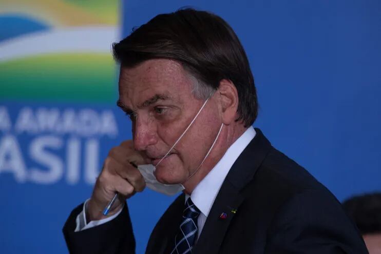 El presidente de Brasil, Jair Bolsonaro, se quita una mascarilla en el acto oficial,