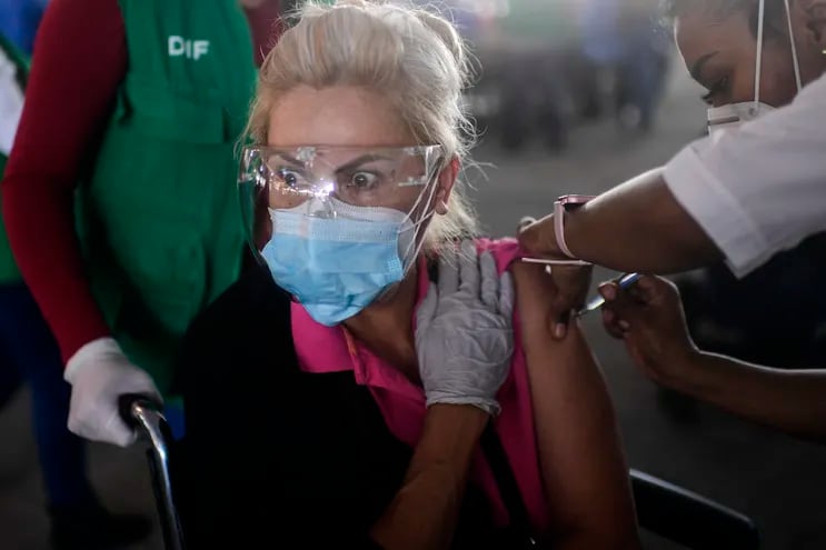 Una anciana recibe una dosis de la vacuna CoronaVac contra COVID-19 en un centro de vacunación de la Ciudad de México, el 17 de marzo de 2021.